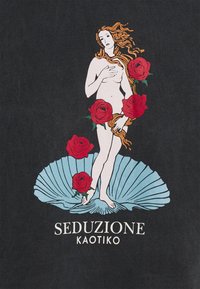 T-shirt grafico con una figura nuda che tiene rose rosse, con uno sfondo blu a conchiglia su uno sfondo scuro; il testo dice "SEDUZIONE KAOTIKO."