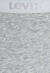 Grå bomullsbelte med brodert "Levi's"-logo i lys grå. Hovedstoffet har en melert grå tekstur, med en myk strikket overflate.