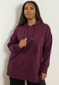 Sudadera burdeos con un corte relajado, capucha con cordón y bolsillo tipo canguro en el frente, fabricada con un tejido suave. Presenta puños y dobladillo acanalados.