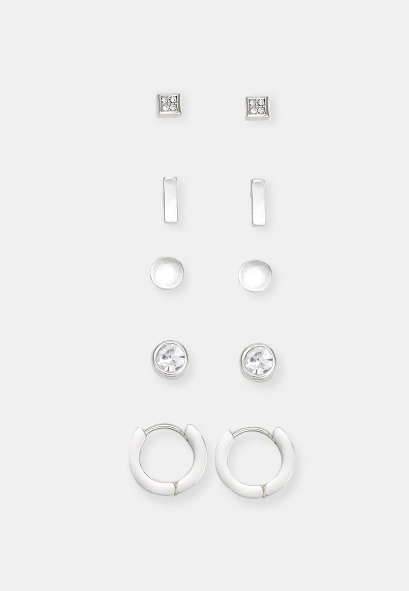 Conjunto de pendientes de plata que incluye dos pares de tachuelas y un par de aros. Presenta piedras preciosas claras y una textura pulida y suave.