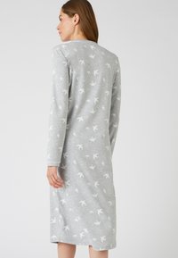 Camicia da notte grigia con maniche lunghe, realizzata in tessuto morbido, caratterizzata da un sottile motivo di uccelli bianchi sulla superficie, con scollatura rotonda e vestibilità comoda.