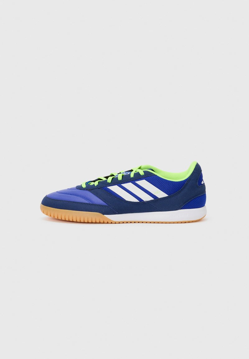 Zapatillas deportivas azules con rayas blancas, que cuentan con una parte superior de malla, suela de goma y acentos en verde neón en el cuello y los cordones.