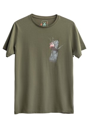 T-shirt en coton vert olive avec un graphisme d'un arbre et d'une boîte aux lettres pour oiseaux. Manches courtes, col rond et texture douce.