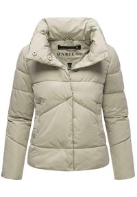 Doudoune beige clair pour femme avec col montant, boutons-pression sur les poches avant et les poignets, et étiquette de marque visible à l’intérieur du col.