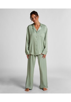 Helles grünes Satin-Pyjama-Set mit einem knöpfbaren Hemd mit Brusttasche und locker sitzenden Hosen mit weitem Bein. Glatte Textur.