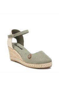 Sanda en cuña de ante verde con punta cerrada, correa ajustable en el tobillo, suela de yute trenzado y patrón de pata de gallo en el tacón.