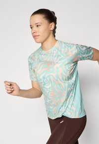 Camisa atlética ligera en verde menta con un patrón abstracto en coral, con mangas cortas y un escote redondeado.