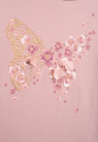 Helles Pinktuch mit einem großen goldenen Glitzer-Schmetterling, umgeben von pastellfarbenen Blumen, mit strukturierten floralen Applikationen und Pailletten.