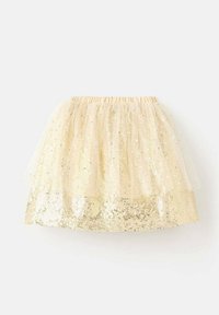 Jupe superposée avec une taille élastique, ornée d'un bas en sequins dorés et d'un voile en tulle transparent. La couleur est un beige doux.