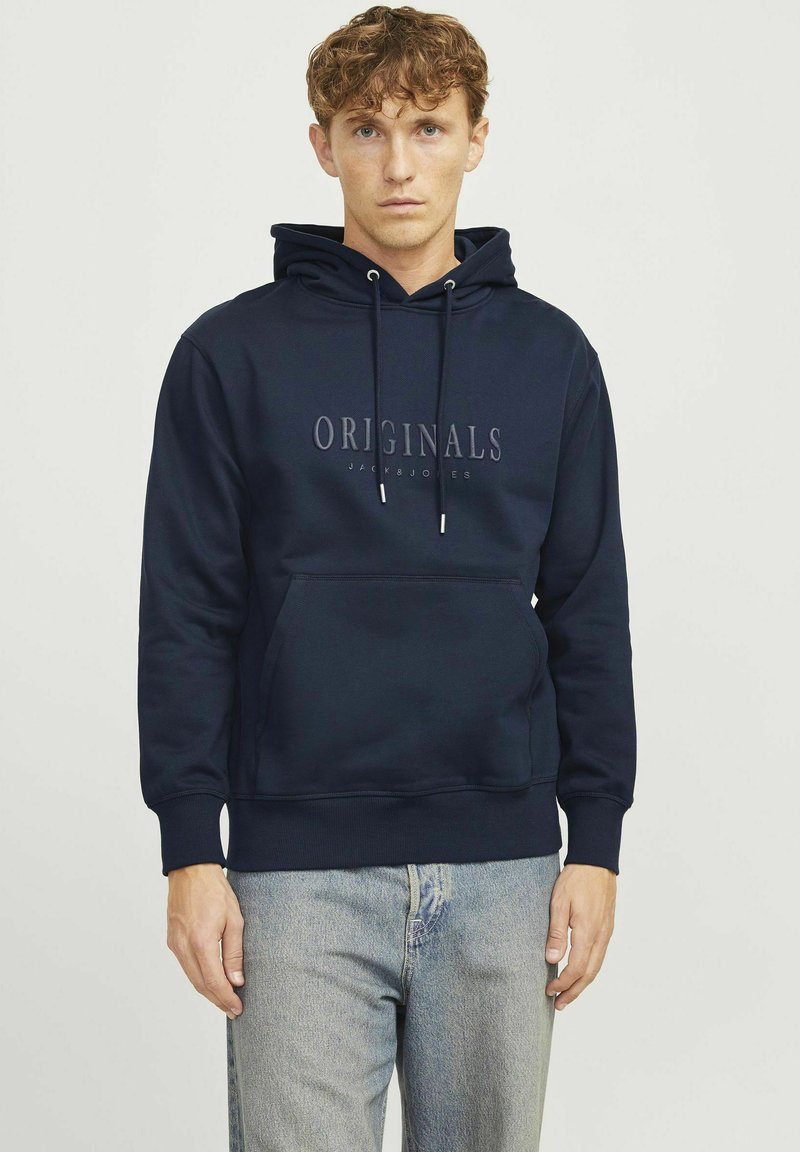 Marineblå hoodie lavet af sweatstof, med en frontlomme, snørehætte og "ORIGINALS JACK & JONES" trykt på brystet.