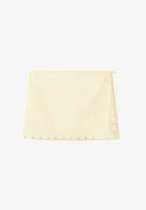 Jupe portefeuille couleur crème avec lien latéral et ornements en perles le long de l'ourlet et du bord latéral.