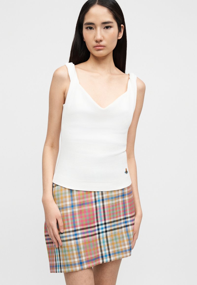 Weißes, figurbetontes Trägershirt mit V-Ausschnitt und breiten Trägern, kombiniert mit einem bunten, karierten Minirock in Blau-, Pink- und Brauntönen.
