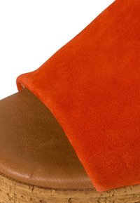 Oranger Wildleder-Sandalette mit Knöchelriemen und einer Kork- sowie braunen Ledersohle. Das Design hat einen breiten Riemen und eine strukturierte Oberfläche.