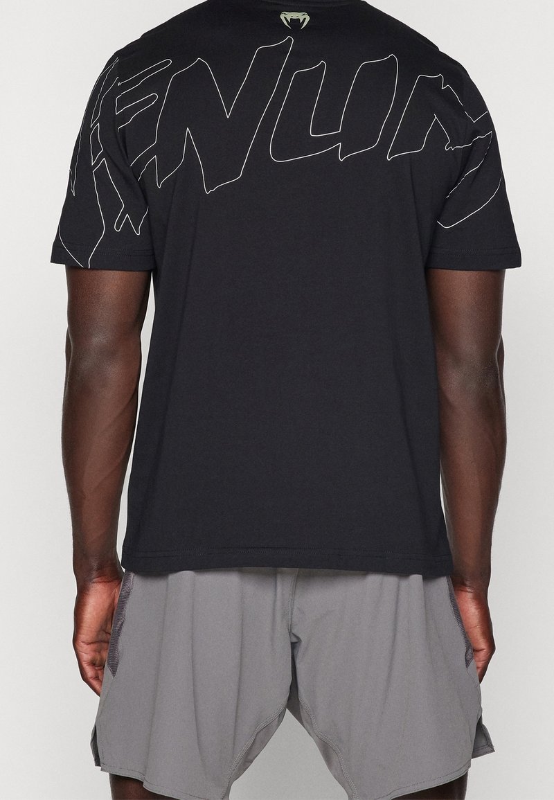 Camiseta de algodón negra con gran texto gráfico blanco en la parte posterior. La camiseta tiene mangas cortas y un escote redondo.