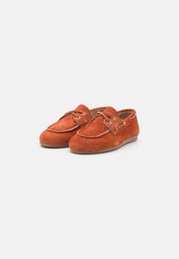 Scarpe mocassino in suede arancione con punta rotonda, cuciture a contrasto e lacci con tre occhielli. Suola in gomma flessibile per un maggiore comfort.
