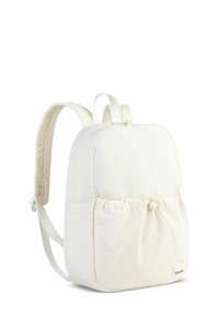 Light cream backpack with a soft, textured exterior, adjustable padded straps, and a cinched front pocket detail. Clean design, minimal hardware.