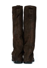 Brązowe zamszowe botki do kolan o miękkiej fakturze, z dwoma tylnymi uchwytami i niewielkim obcasem dla dodatkowego wsparcia.