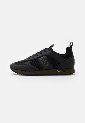 Schwarzer Sneaker in niedriger Ausführung mit Mesh- und synthetischen Einsätzen, Schnürung vorne, olivgrüner Sohle und "EA7 Emporio Armani" Branding an der Seite.