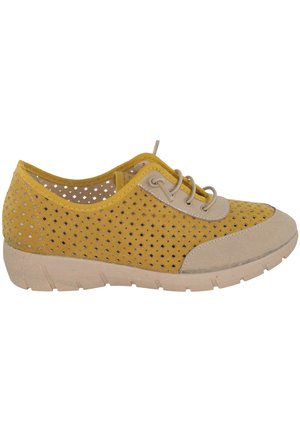 Zapato deportivo amarillo con cordones, acentos beige en la puntera y el talón, laterales perforados para una mejor transpiración y suela de goma beige.