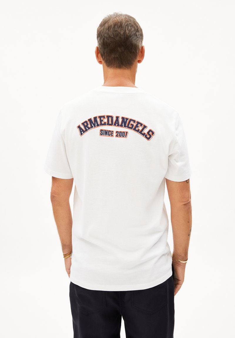 Weißes Baumwoll-T-Shirt mit gesticktem "ARMEDANGELS"-Text in Rot und Marineblau auf dem Rücken. Kurze Ärmel und lockere Passform.
