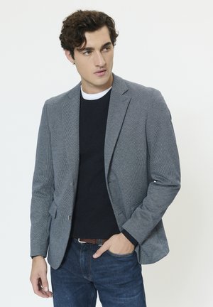 Sako v kockovanom vzore psie zuby, svetlosivá a tmavomodrá, jednorzadové s výrezovými klopami, kombinované s námorníckym svetríkom a džínsami.