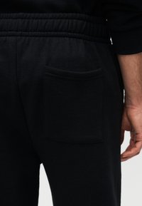 Μαύρο παντελόνι φόρμας με απαλή υφή, διαθέτει ελαστική μέση και πίσω τσέπη. Το ύφασμα είναι μαλακό, ελαφρύ βαμβακερό μείγμα.