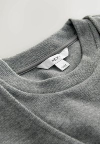 Grå crew-neck sweatshirt med en struktureret stof, der har et mærke med "NEXT". Udrigningen har en ribbet kant.