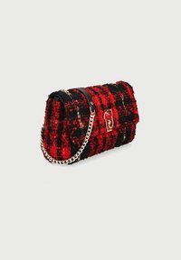 Bolso de hombro de tweed rojo y negro, de forma rectangular, con una correa de cadena en tono dorado y un acento en piel negra. Patrón texturizado notable.