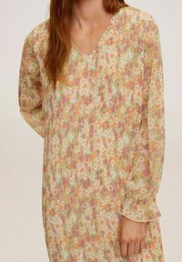 Blumenmusterkleid aus leichtem, transparentem Stoff mit V-Ausschnitt und langen, leicht gerafften Ärmeln. Farben sind Pastellgelb, Rosa und Grün.