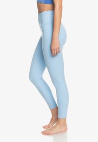 Lichtblauwe leggings met een hoge taille, soepel materiaal en een aansluitend ontwerp. Het materiaal heeft een matte afwerking met subtiele stikseldetails.