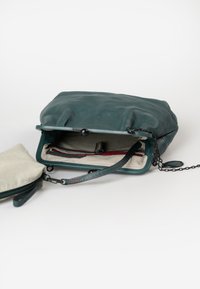 Türkise Ledertasche mit strukturierter Oberfläche, ausgestattet mit einem gestreiften Innenfutter und einer Kettenriemen. Enthält eine zusätzliche kleinere, mit Reißverschluss verschlossene Tasche.
