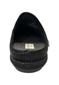 Zwarte instapslipper met witte stiksels en een zachte grijze binnenzool met een label, gezien vanuit de voorkant.