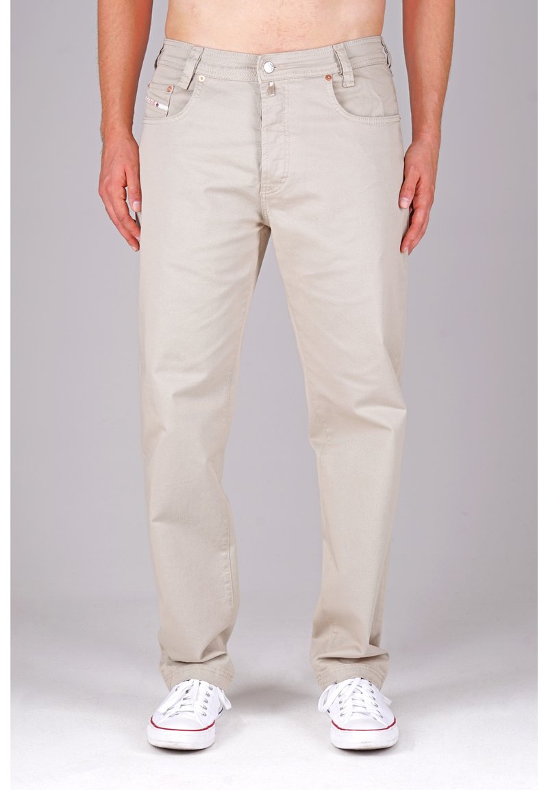 Beige Baumwollhosen mit geradem Schnitt, fünf Taschen-Design, Knopf- und Reißverschluss, und weiße Sneakers mit roten Akzenten.