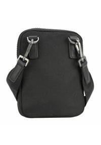 Bolso cruzado de nylon negro con herrajes plateados, forma cuadrada, cierre en la parte superior y correa ajustable. Material texturizado y diseño minimalista.