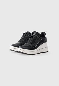 Sneakers wedge neri e grigi con suole platform bianche e lacci sul davanti, caratterizzate da un tessuto a motivo sottile e dettagli metallici.