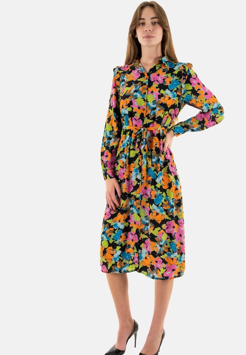 Abito floreale con sfondo nero e motivi vivaci in rosa, arancione, verde e blu, con chiusura a bottoni e vita con cintura.