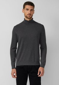 Ciemnoszary golf wykonany z miękkiego materiału, o dopasowanym kroju i żeberkowanych mankietach. Minimalistyczne logo na dole.