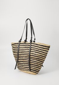 Striped straw tote bag with black leather straps. Features a triangular shape, natural and black color scheme, and woven texture.