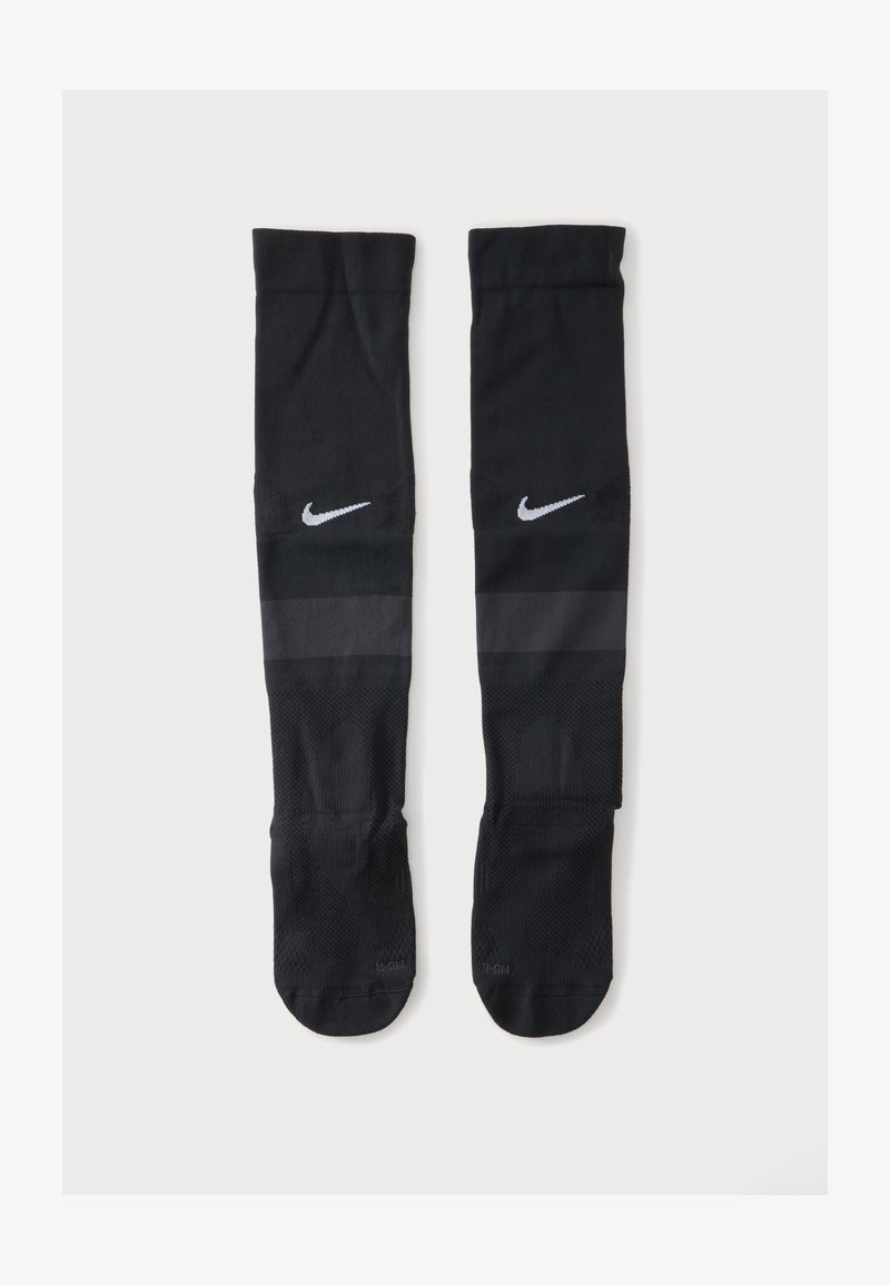 Ζευγάρι μαύρες αθλητικές κάλτσες Nike μέχρι το γόνατο με λευκό λογότυπο Nike swoosh κοντά στην κορυφή και μια διακριτική σκοτεινή λωρίδα κάτω από το λογότυπο.