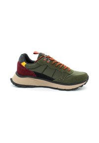 Sneaker verde realizzato con un mix di materiali scamosciati e tessili, lacci arancioni, dettagli neri e una spessa suola beige con battistrada testurizzato.