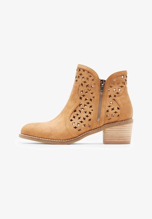 Barna suéd bőr bokacsizma kivágott csillagmintákkal, oldalsó cipzárral és facsászlós sarokkal. Sima textúra és lekerekített orrforma.