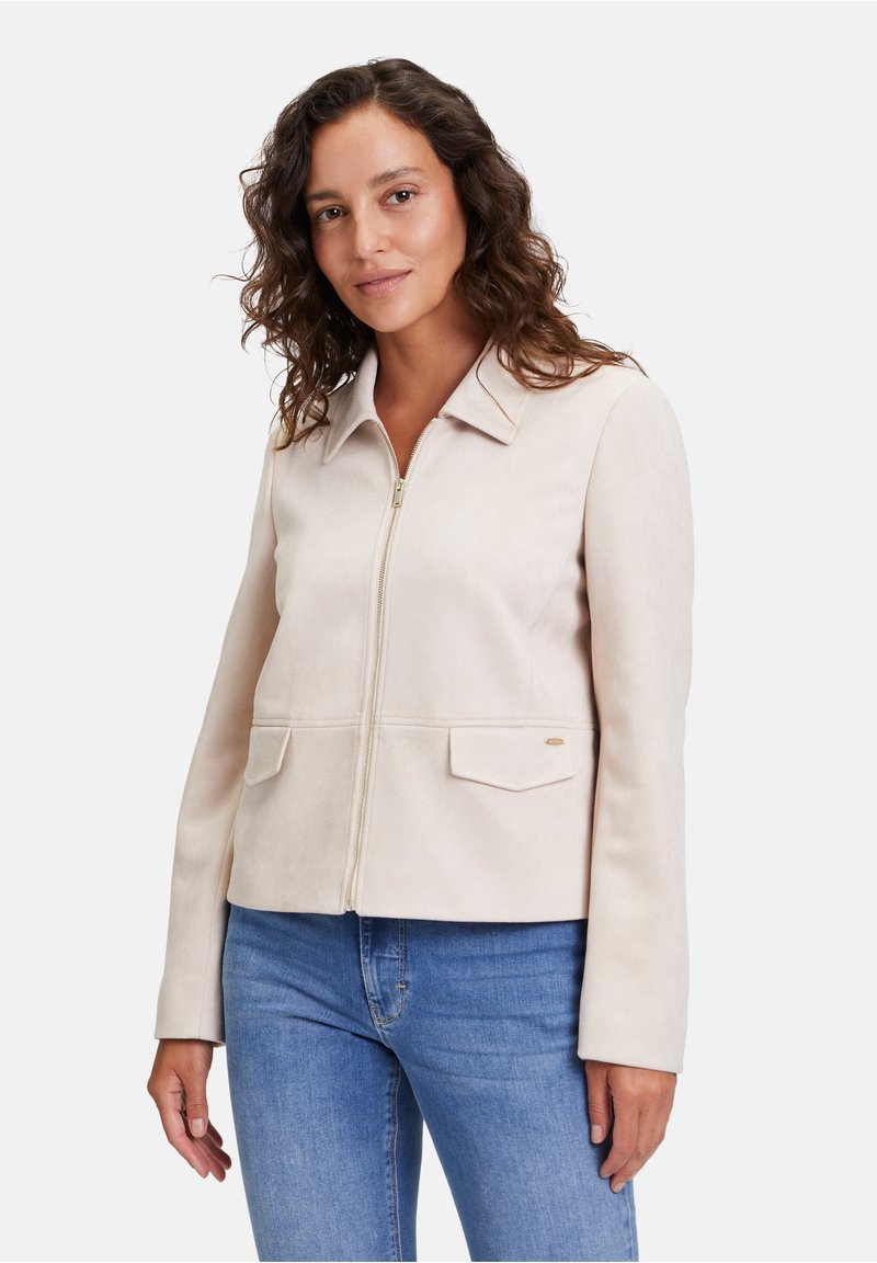 Ljust beige mockapälsjacka med krage, främre dragkedja och två ficklock. Slät textur och skräddarsydd design med långa ärmar.