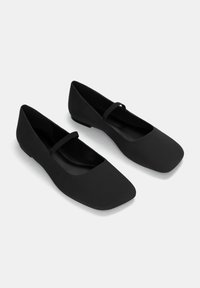 Schwarze flache Schuhe mit einer quadratischen Zehenform und einem schmalen Riemen über dem Spann. Hergestellt aus glattem Stoff mit matter Oberfläche.