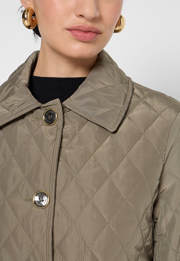 Kaki gep quiltete Jacke mit großem Kragen, ausgestattet mit einem auffälligen goldenen Knopf und glatter, glänzender Stofftextur.
