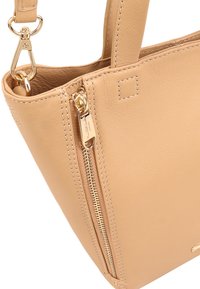 Tanskleurige leren handtas met een ritsvak, gouden hardwareaccenten en zichtbare stikdetails. Compacte vorm met een gestructureerde uitstraling.