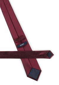 Cravate bordeaux en tissu lisse, avec une pointe et une boucle cachée. Étiquette de marque "JOOP!" en bleu foncé visible.
