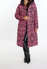 Różowo-czarna kurtka puchowa w paski zebry z kapturem, wyposażona w zamknięcie na zamek, boczne kieszenie oraz pikowany wzór.