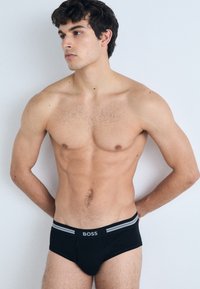Zwarte katoenen boxershorts met grijze gestreepte tailleband met het "BOSS"-logo. Gladde textuur en strakke pasvorm.