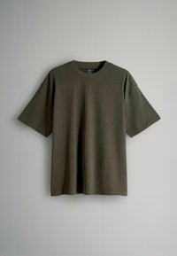 Olive zaļš kokvilnas T-krekls ar īsām piedurknēm, apaļu kakla izgriezumu, brīvu piegriezumu, gludu tekstūru un bez redzamām rakstām vai akcentiem.