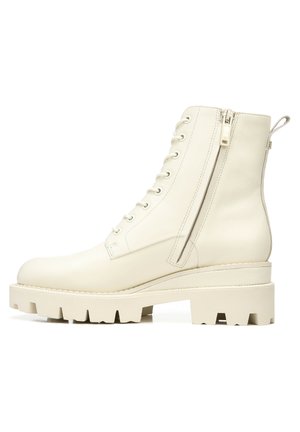 Bottes de cheville en cuir blanc chunky avec un bout arrondi, un laçage sur le devant, une fermeture éclair sur le côté et une semelle épaisse et texturée.